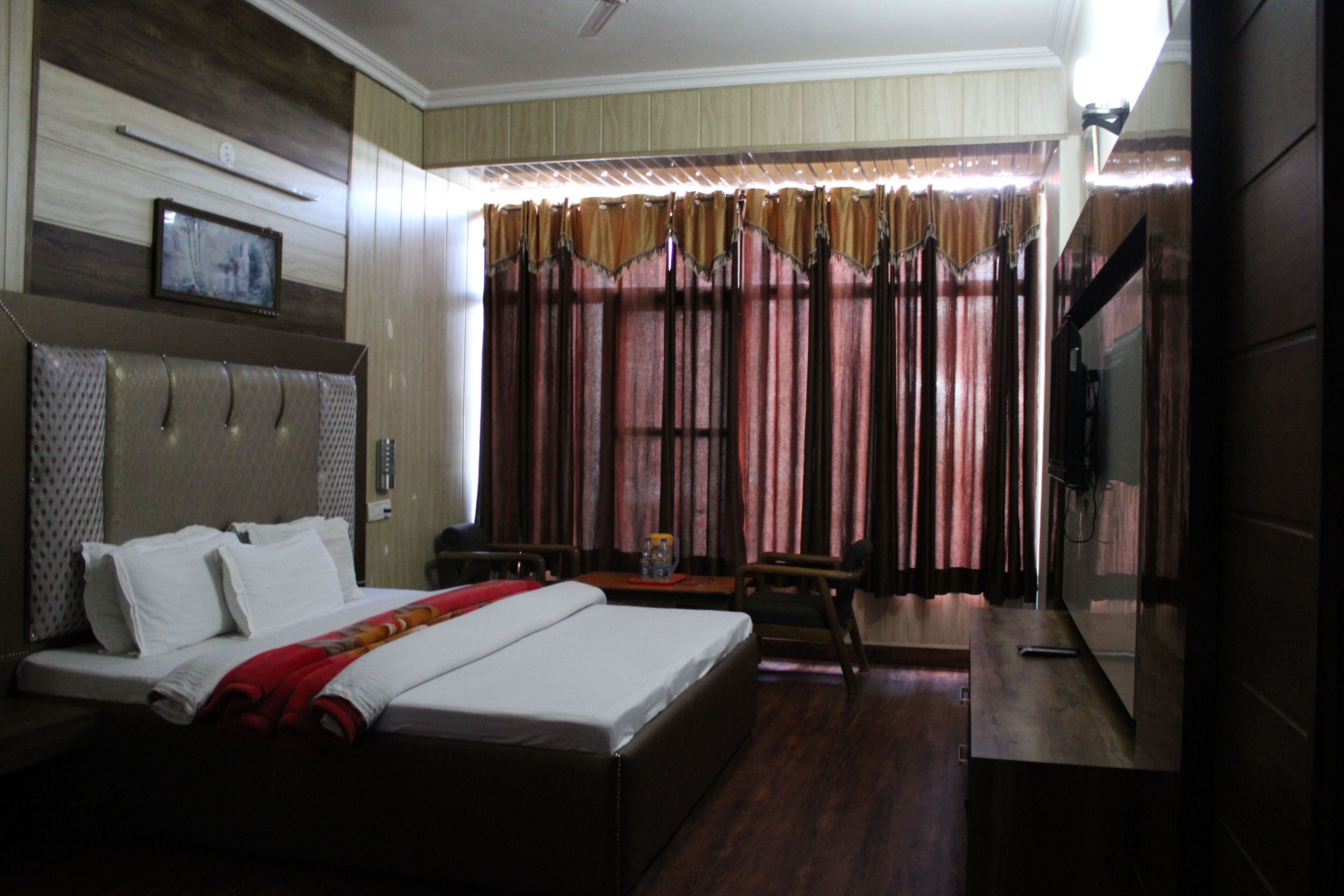 Une chambre d’hôtel avec un grand lit, un bureau et une télévision.