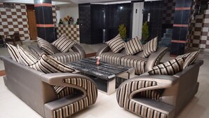 A modern lounge area with a sofa set and a central coffee table. - Hotel President (Dalhousie)