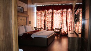 A hotel room with a large bed, a desk, and a chair. - Hotel President (Dalhousie)