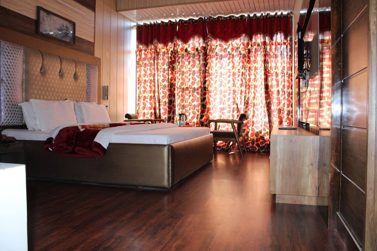 Un dormitorio con una cama grande, un escritorio de madera y una silla.