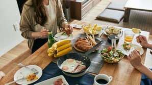A breakfast table with various dishes including eggs, toast, bananas, and a salad.