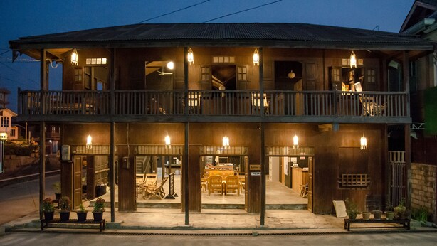A two-story wooden building with a balcony, outdoor seating, and a dining area. - Hardwood Lodge - Hostel (Nyaungshwe)