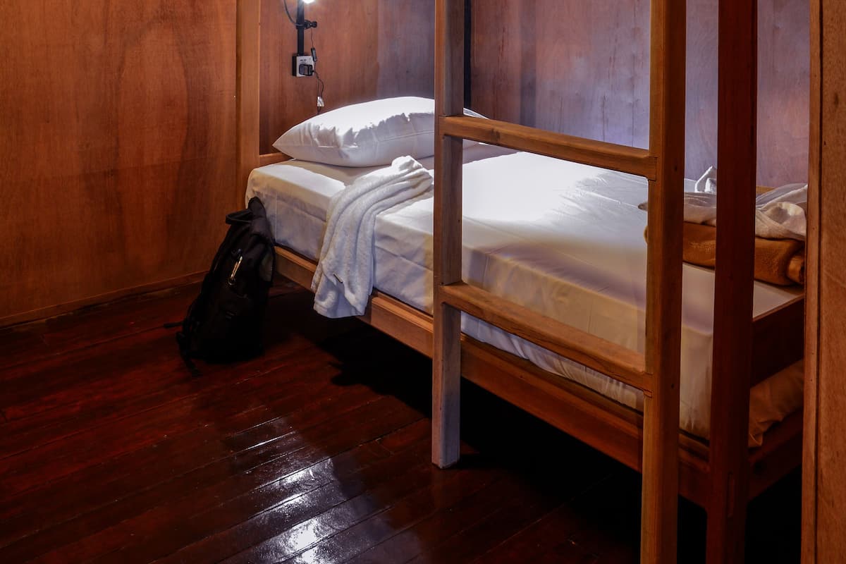A bunk bed room with wooden walls and a single light fixture.
