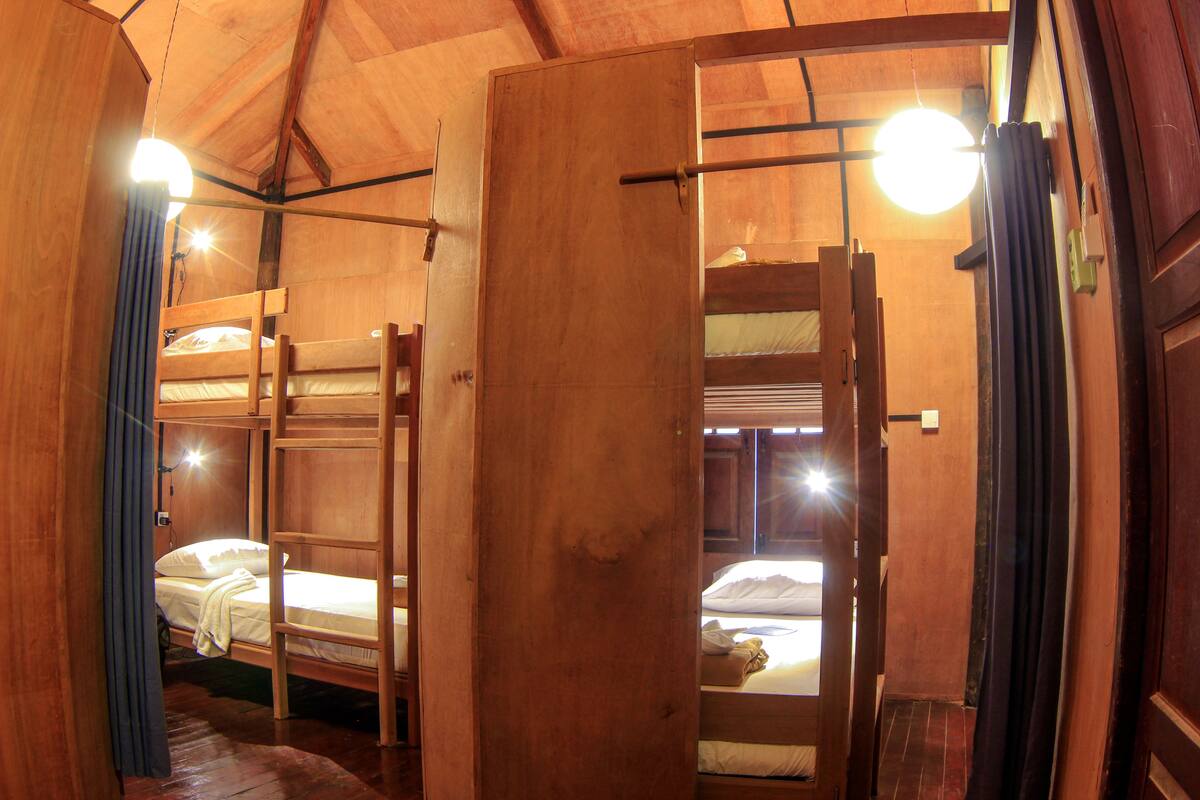 A wooden interior with bunk beds and a visible door.