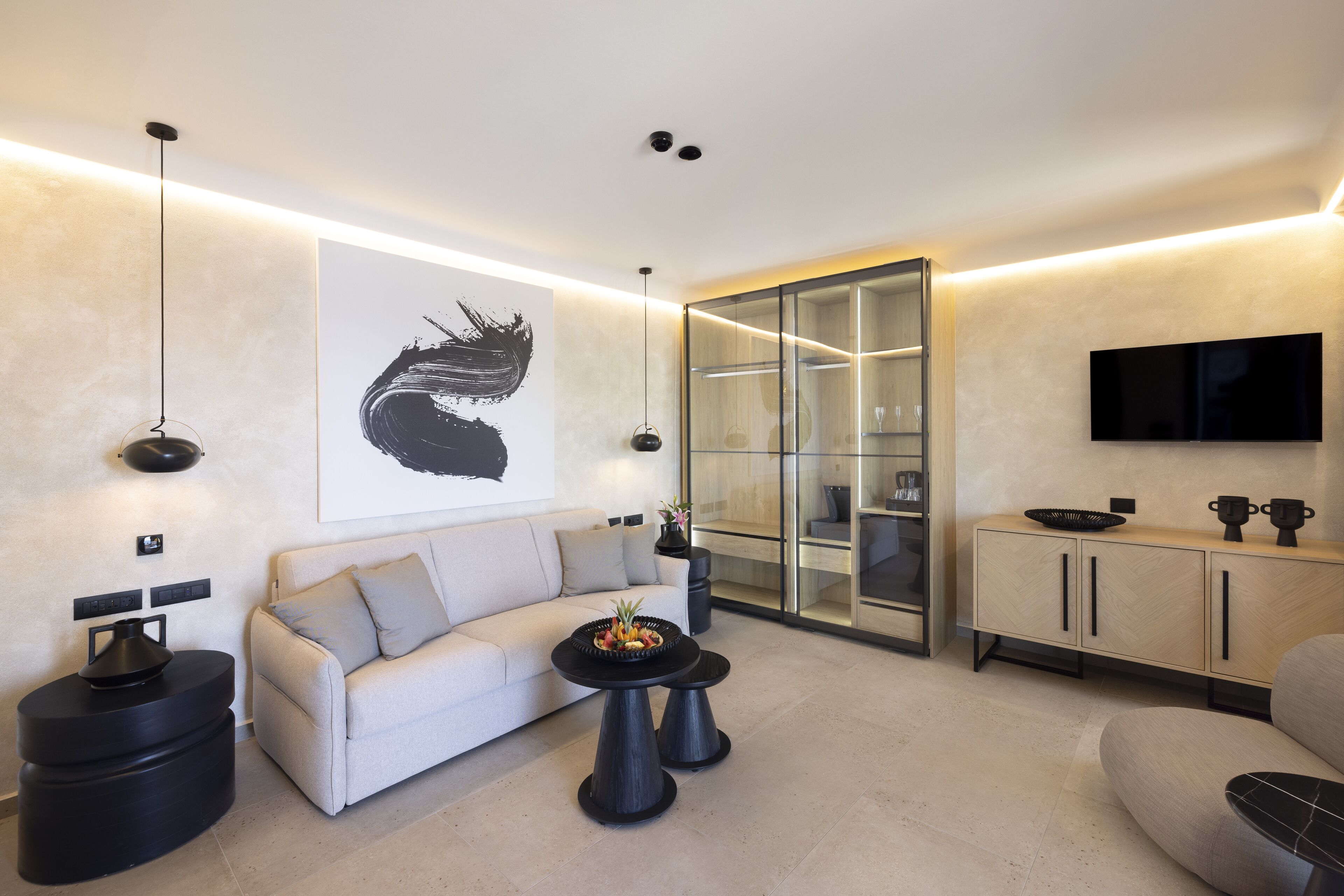 A modern living room with a sofa, coffee table, and a glass cabinet.