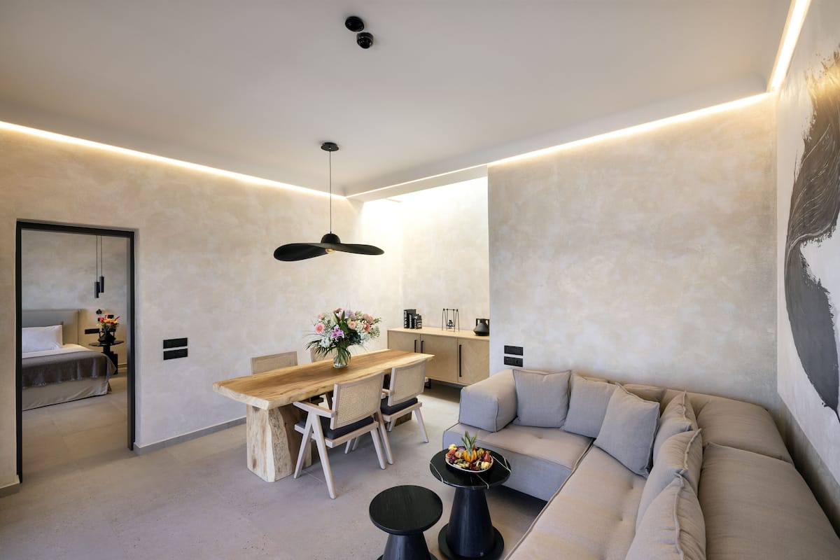 A modern interior with a dining area, sofa, and kitchen.