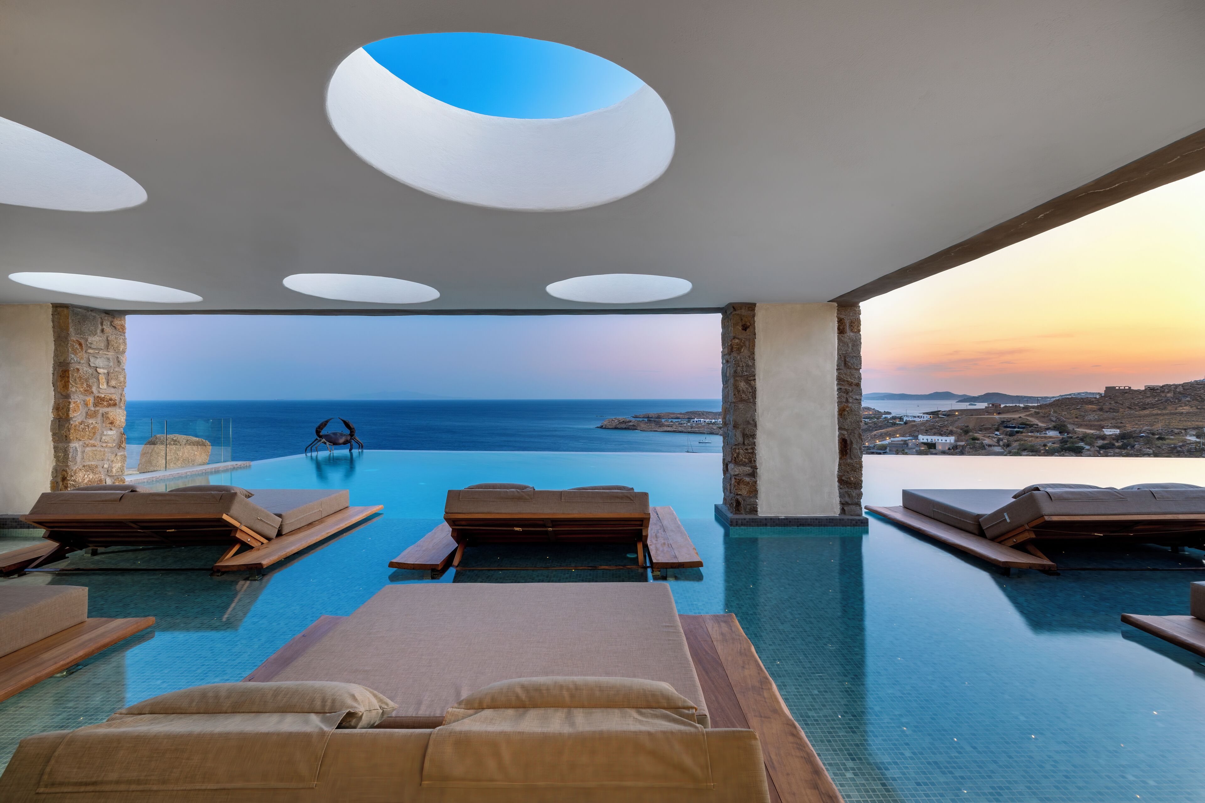 An infinity pool with lounge chairs and a view of the sea.
