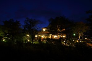 A well-lit building surrounded by trees at night. - The Wonderland B&B (Ji'an)