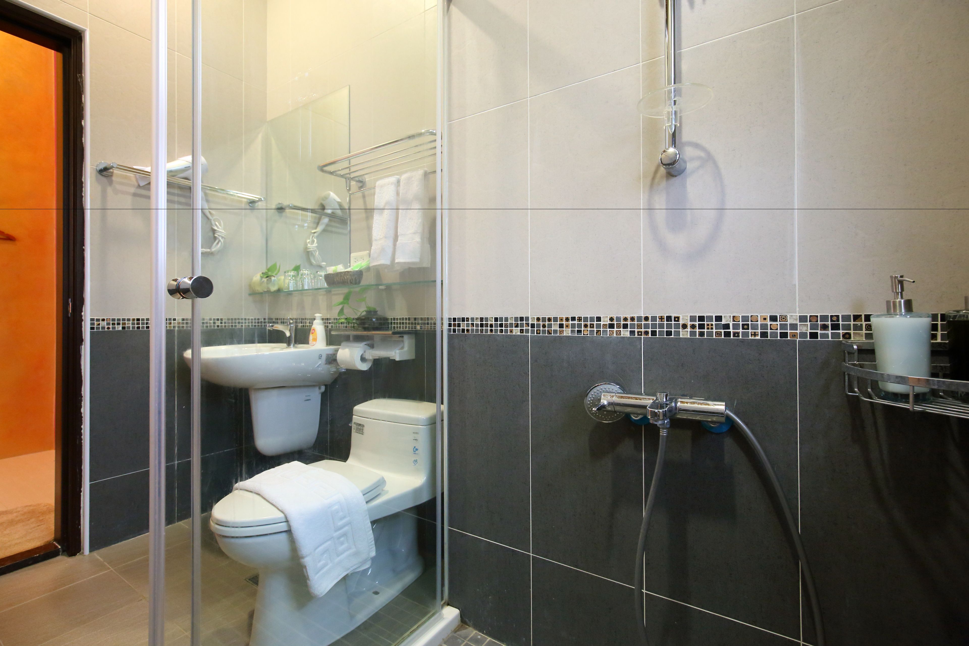 Un baño moderno con ducha de vidrio, inodoro y lavamanos.