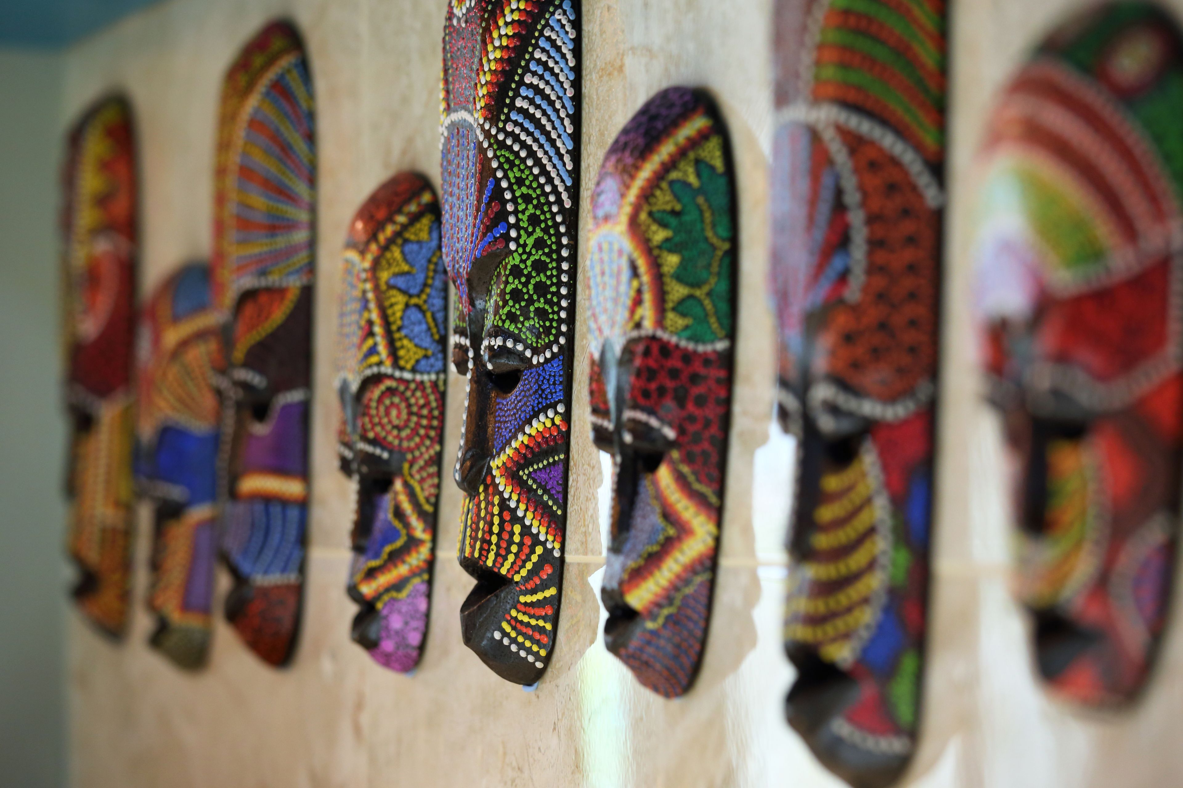 A row of intricately designed wooden objects with colorful patterns.