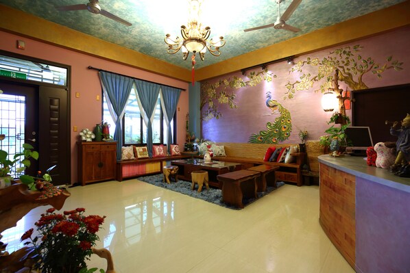 A living room with a sofa set, wooden coffee table, and a decorative wall mural. - The Wonderland B&B (Ji'an)