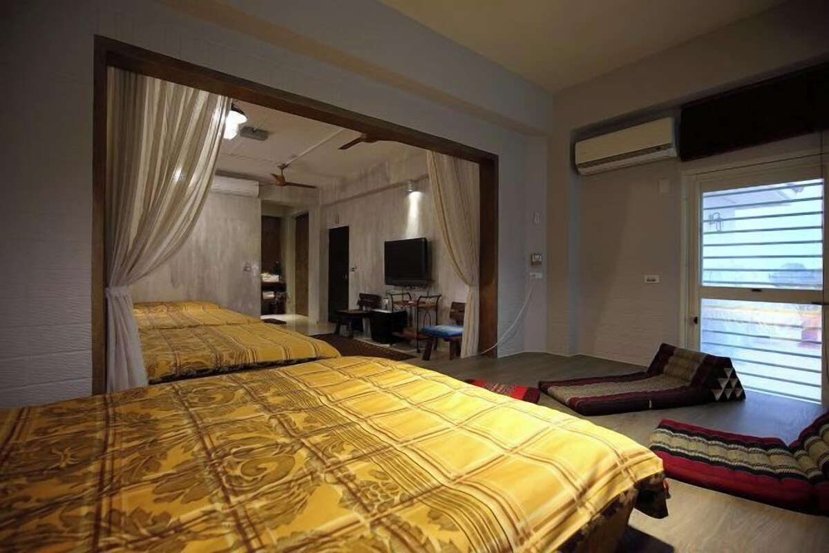 Un dormitorio con dos camas, un escritorio, una silla y una televisión.