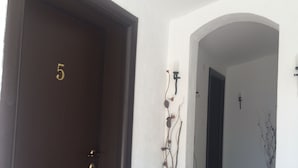 Un pasillo con una puerta de madera oscura marcada con el número 5, que da a una habitación.