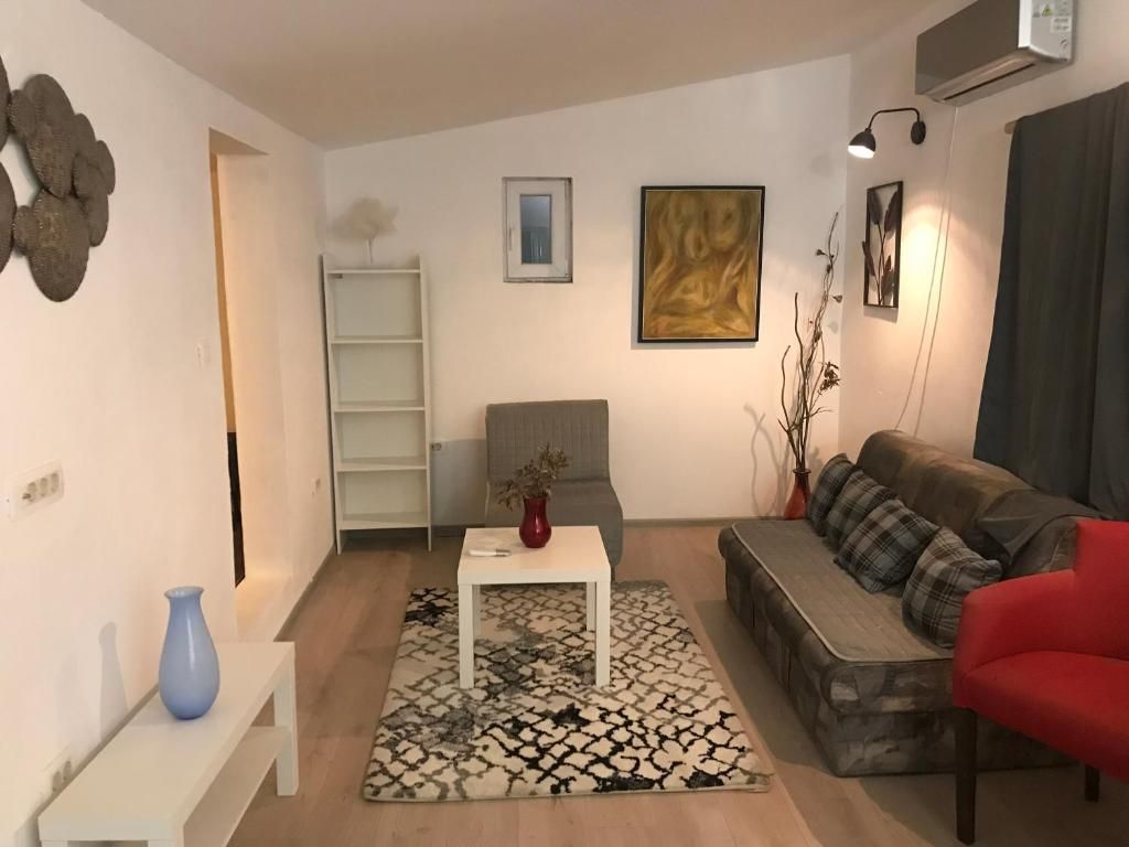 Un saló amb un sofà, una taula de centre, una biblioteca i un quadre a la paret.