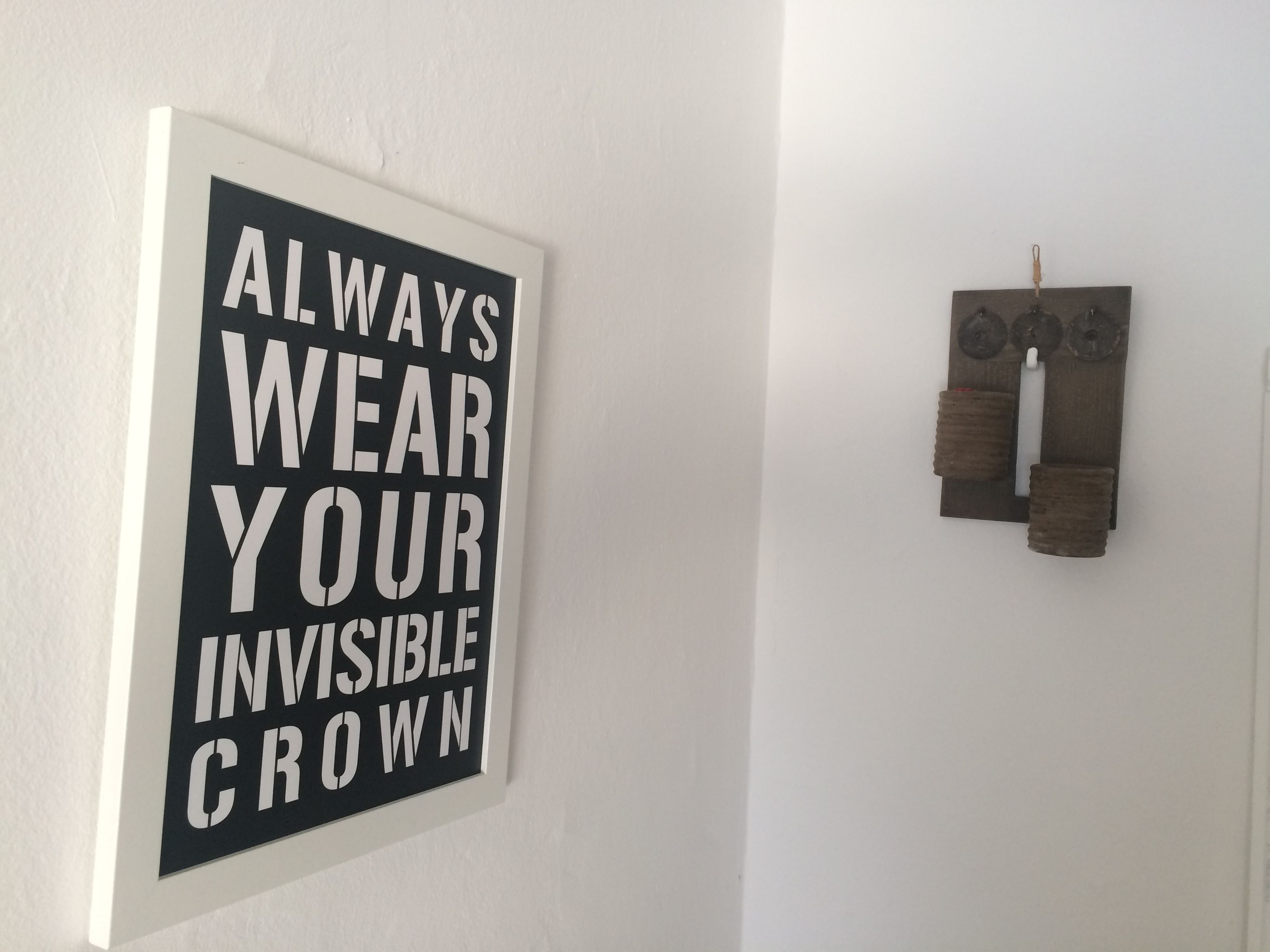 Un mur orné d’un panneau encadré sur lequel on peut lire : « PORTEZ TOUJOURS VOTRE COURONNE INVISIBLE ».
