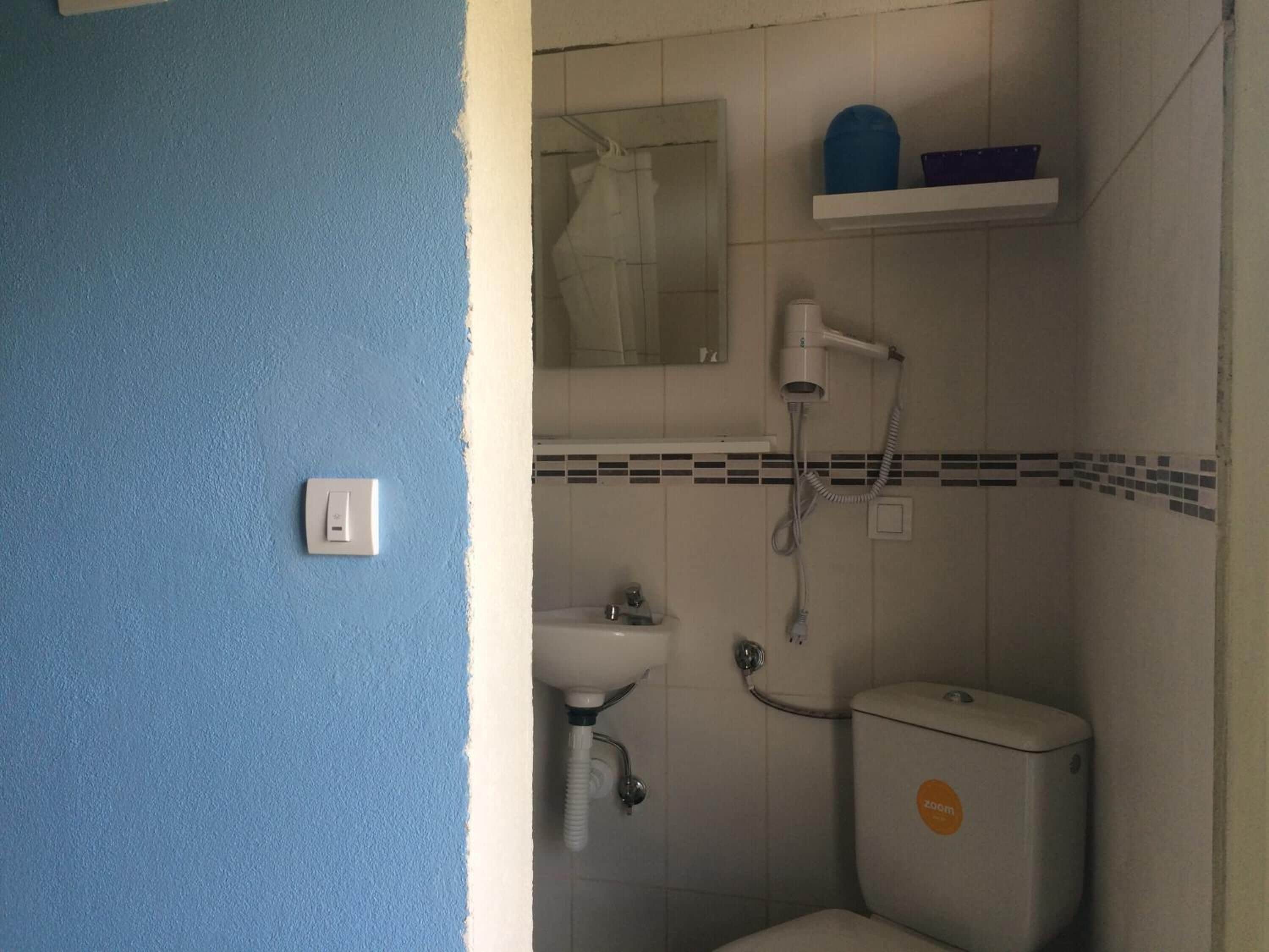A bathroom with a toilet, sink, and shower.