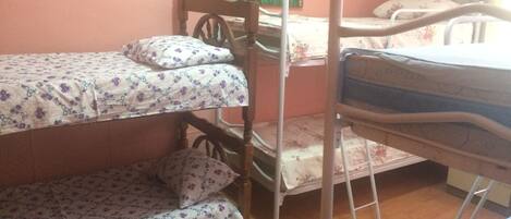 A bunk bed room with floral bedding and a painting on the wall.