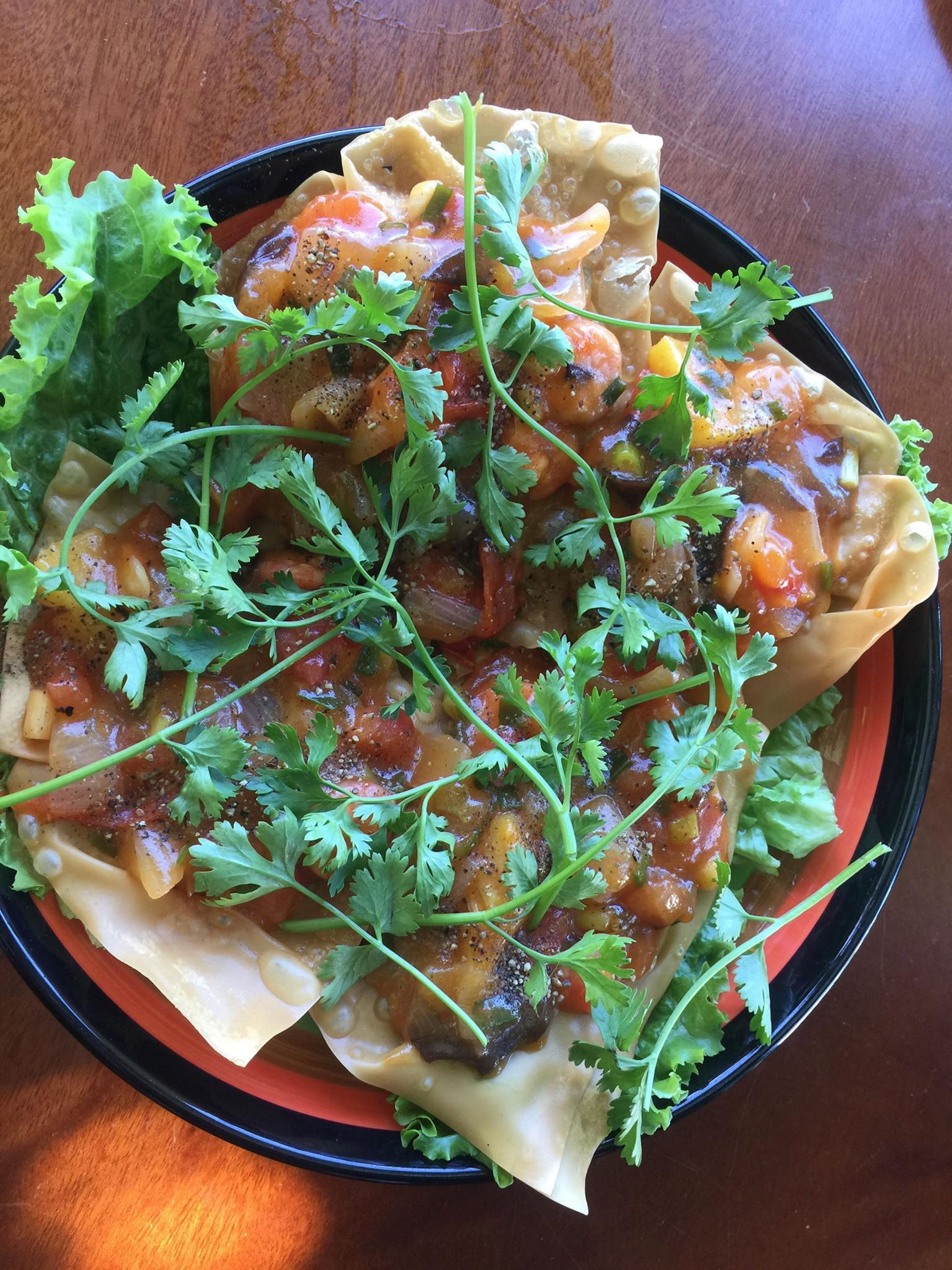 Eine Schüssel mit gefüllter Pasta, Gemüse und Kräutern.