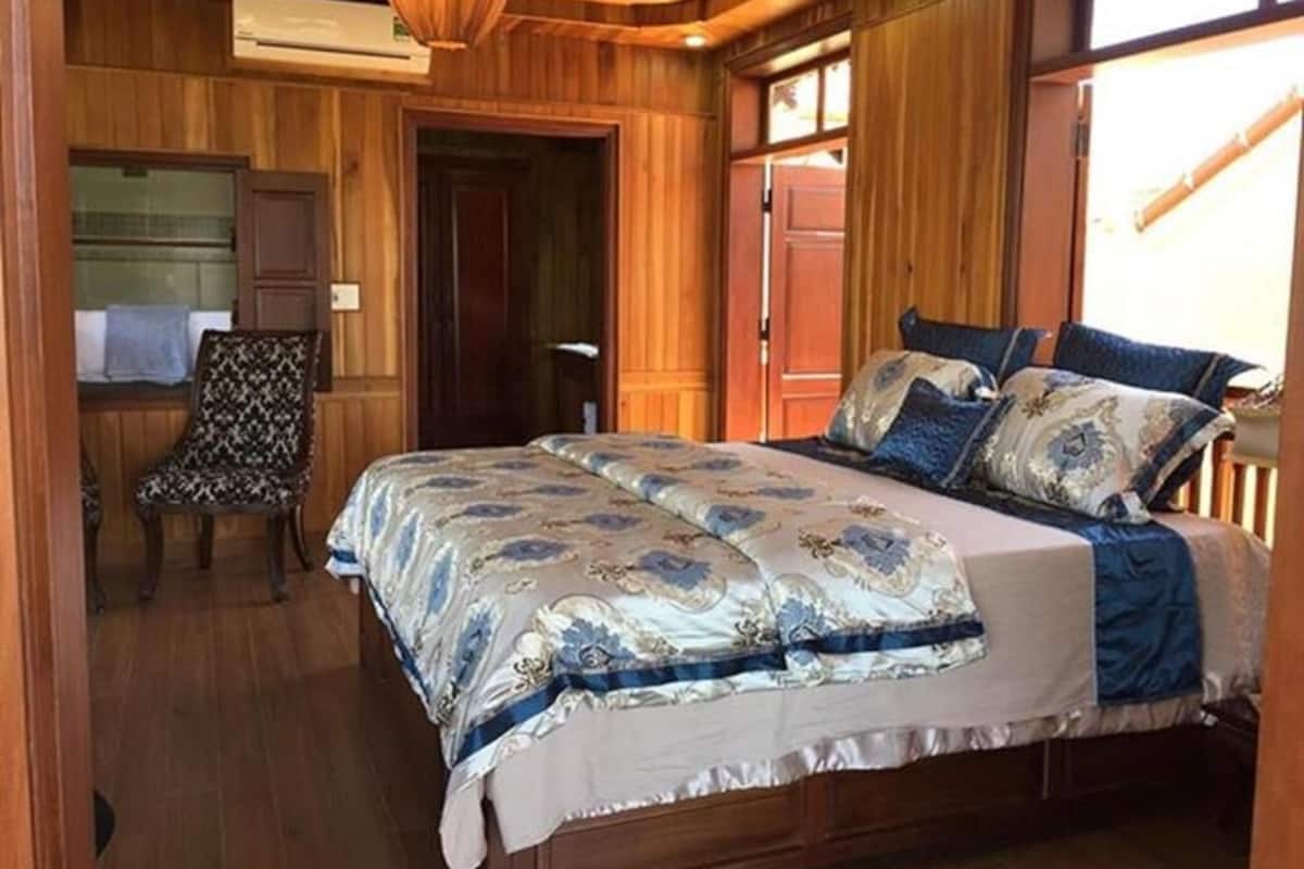 Una habitación de madera con una cama, una silla y una puerta.