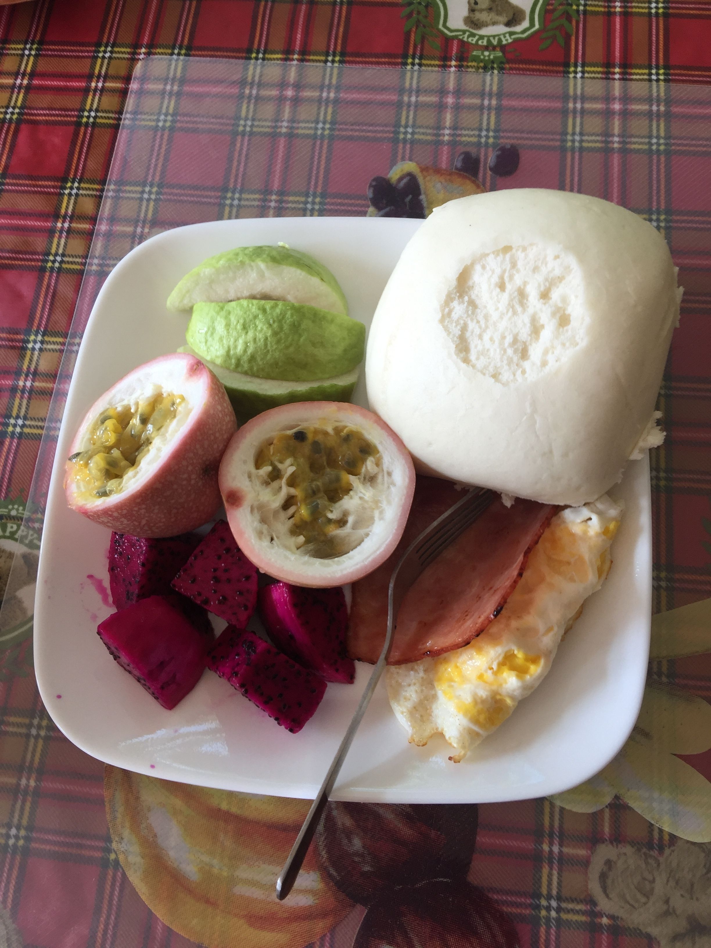 A plate with a variety of foods including a fruit, a vegetable, and a meat dish.
