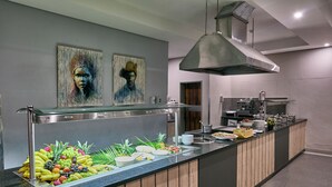 A buffet counter with a variety of fruits and a stainless steel sink. - Kalahari Arms Hotel (Ghanzi)