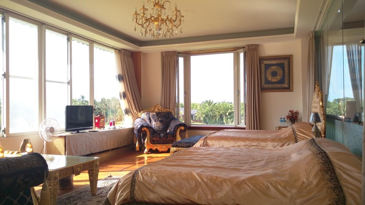 A spacious room with a large bed, a television, and a desk with a computer.