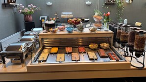 Uma área de buffet com diversos alimentos e acompanhamentos.