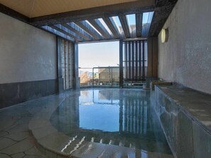 A large indoor swimming pool with a clear view of the sky and distant buildings. - Hotel Oonoya (Atami)