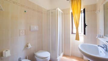 A bathroom with a toilet, sink, and shower.