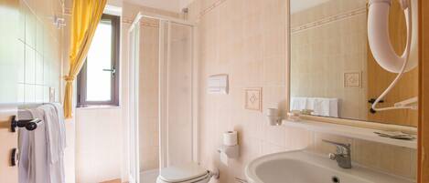 A bathroom with a toilet, bidet, sink, and a mirror.