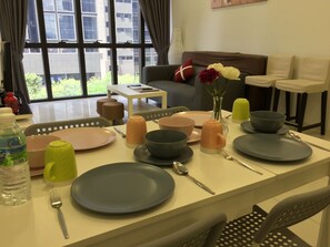 A dining area with a table set for four, including plates, bowls, and cutlery.