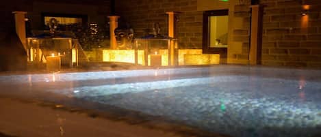 A hot tub area with a brick wall and a window.