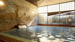 A hot tub with a stone wall and a large window. - Atami Kinjokan (Atami)