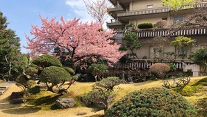 A traditional Japanese garden with a building in the background. - Atami Kinjokan (Atami)