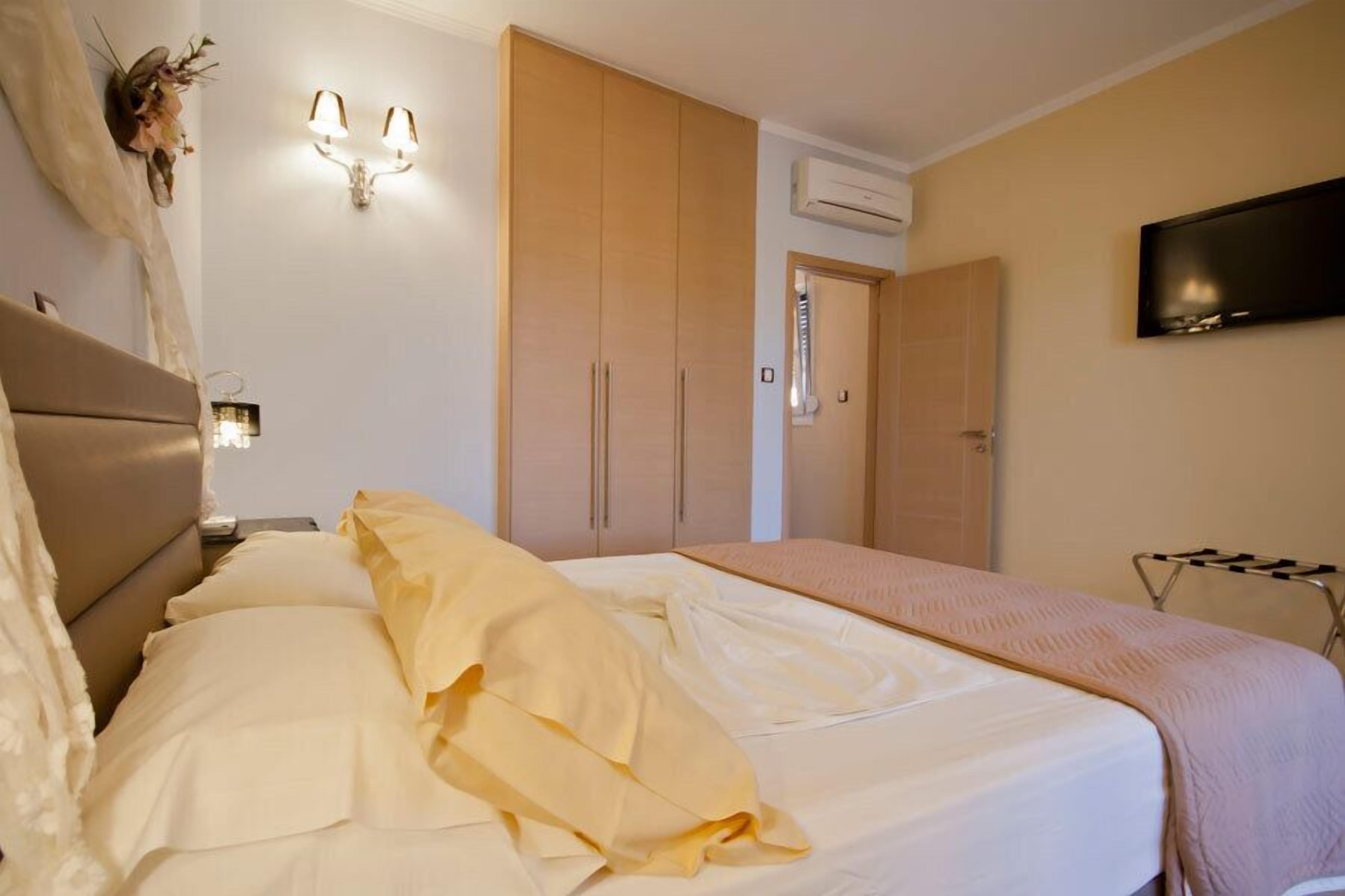 Un dormitorio con cama, armario y televisor en la pared.