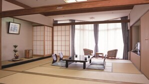 A traditional Japanese room with tatami flooring, a low table with cushions, and sliding shoji doors. - Itoen Hotel Shikisai (Yugawara)