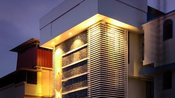 Edifici d'hotel modern amb una secció vertical destacada que presenta llistons horitzontals, una zona d'àmbit superior amb un contenidor verd i una placa visible amb el nom de l'hotel.