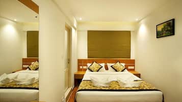 A hotel room with two beds, a large window, and a painting on the wall.