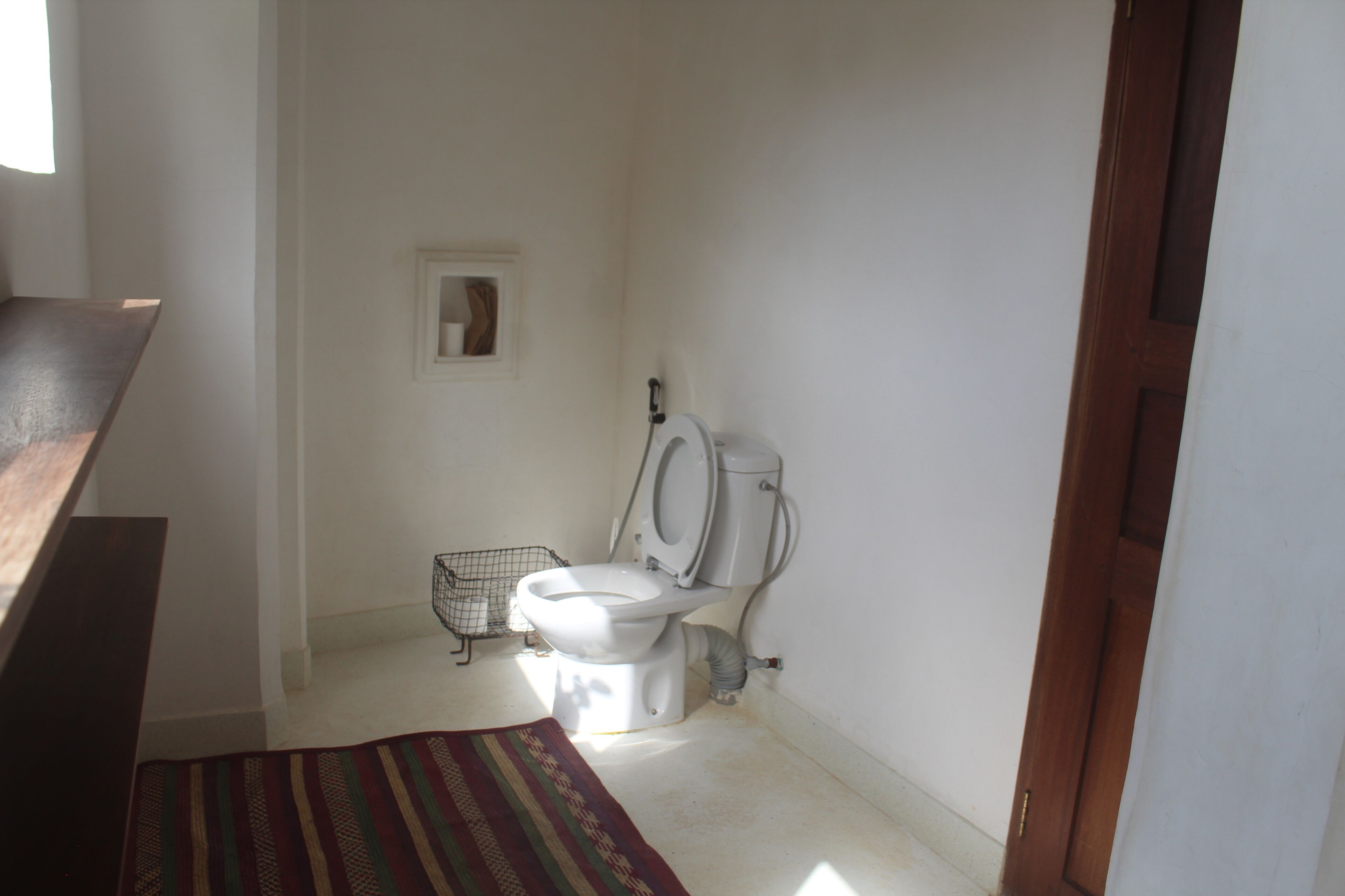 Baño pequeño con inodoro, ducha y ventana.