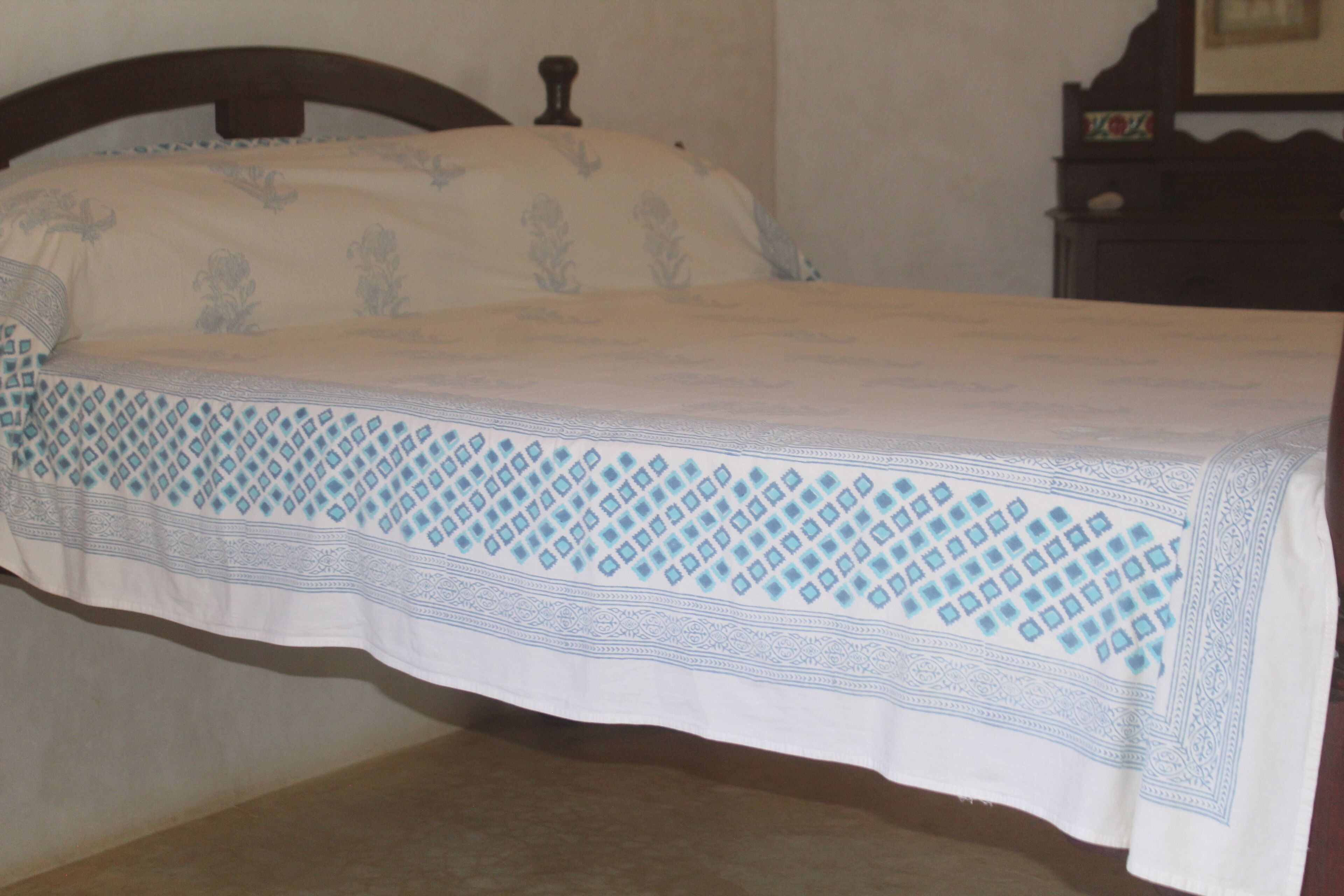 Una cama con colcha y almohadas estampadas.