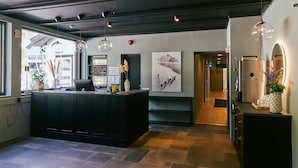 A modern kitchen with a central island, pendant lighting, and artwork on the walls.