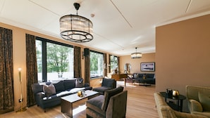 A spacious living room with a sofa set, a coffee table, and a television in the background.