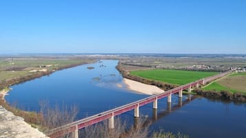 A stone bridge over a calm river with a clear blue sky.