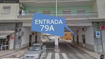 Vista de la calle de un edificio con un cartel que indica 'ENTRADA 79A'.