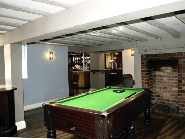 A pool table in a room with a bar area and a brick fireplace. - The Coach Hotel (Birmingham)