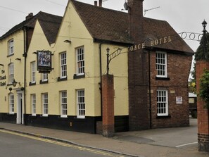 Experience the charm of The Coach Hotel, featuring a traditional facade, prominent signboard, and welcoming entrance.