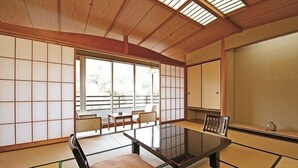 Una habitación japonesa tradicional con suelo de tatami, una mesa baja y puertas correderas.