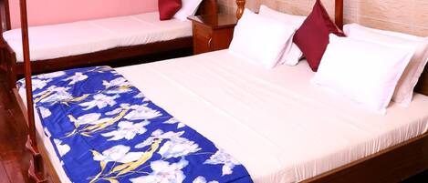 A room with a four-poster bed, a smaller bed, wooden flooring, a ceiling fan, and a lamp.