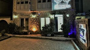 Un hotel con fachada de piedra, un logotipo con una corona y un cartel que dice 'ING. HUIELS'.