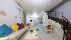 Una sala de estar acogedora con un sofá, una mesa de centro y una escalera que sube a otro nivel.